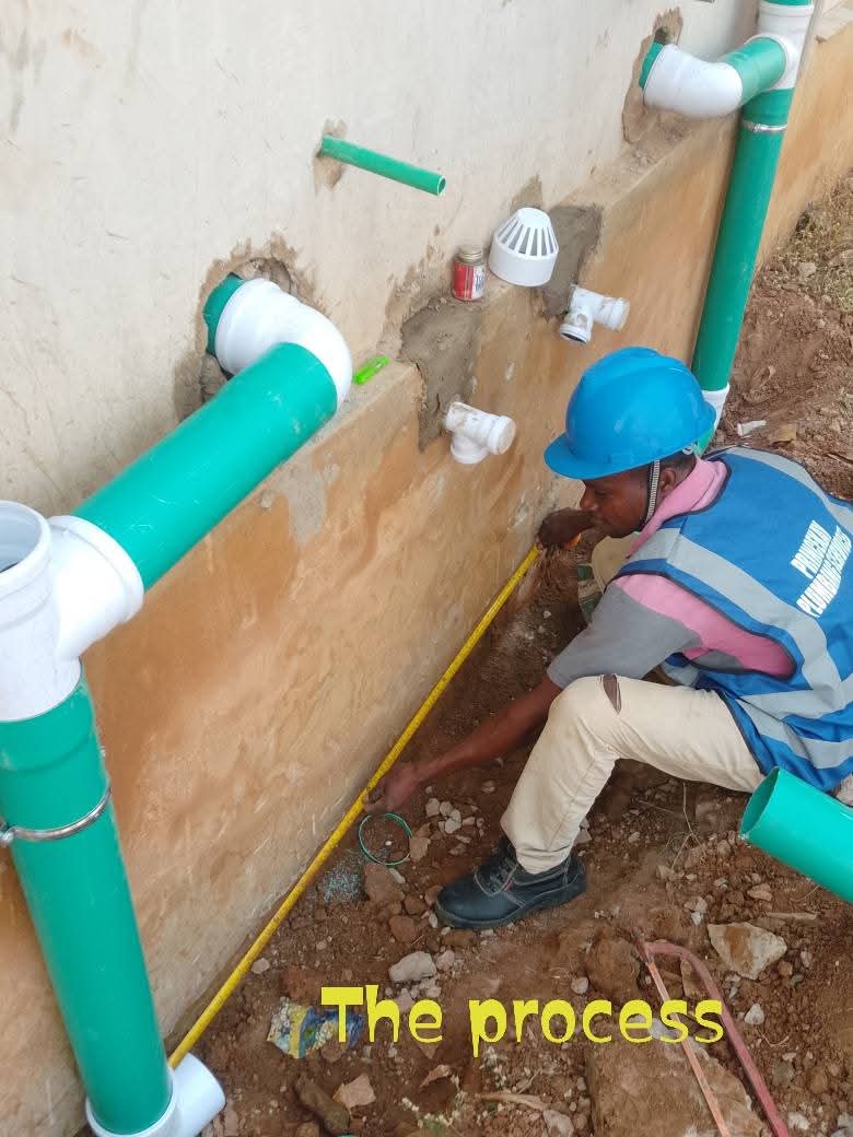 Princekay plumber measuring out external waste and drainage pipework along a wall